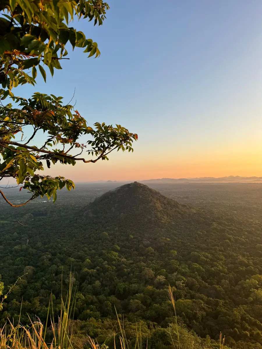 Sunset over Sri Lanka's green mountain landscape